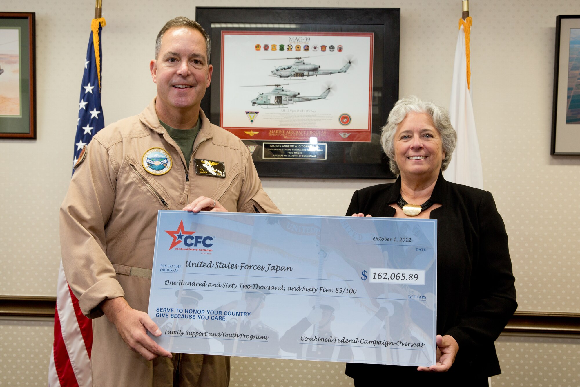 YOKOTA AIR BASE, Japan -- Renee Acosta, president and CEO of Global Impact, the managing company of Combined Federal Campaign-Overseas, presents U.S. Marine Corps Maj. Gen. Andrew O'Donnell Jr., United States Forces, Japan deputy commander, a $162,065 check for family support and youth programs, Oct. 1, 2012, at Yokota Air Base, Japan. In 2011, 17,842 service members from USFJ contributed more than $3.2 million for the CFC-O. (U.S. Air Force photo by Osakabe Yasuo)