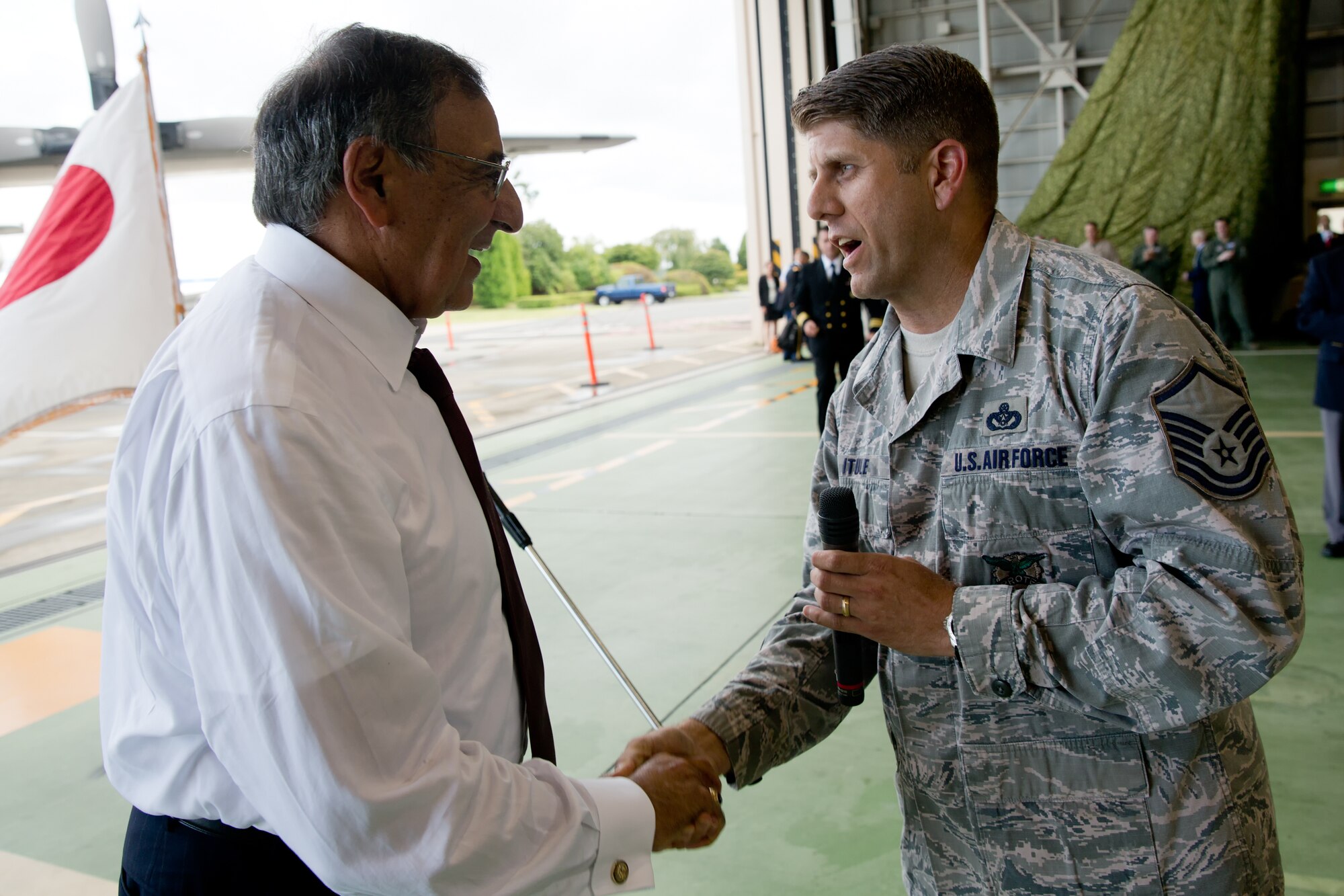 YOKOTA AIR BASE, Japan -- Master Sgt. Fred Itule, 374th Civil Engineer Squadron fire department, presents a Combined Federal Campaign-Overseas coin to Secretary of Defense Leon E. Panetta during his visit to Yokota Air Base, Japan, Sept. 17, 2012. During the campaign season, uniformed and civilian personnel can contribute to help people in need across the Nation and around the world. (U.S. Air Force photo by Osakabe Yasuo)