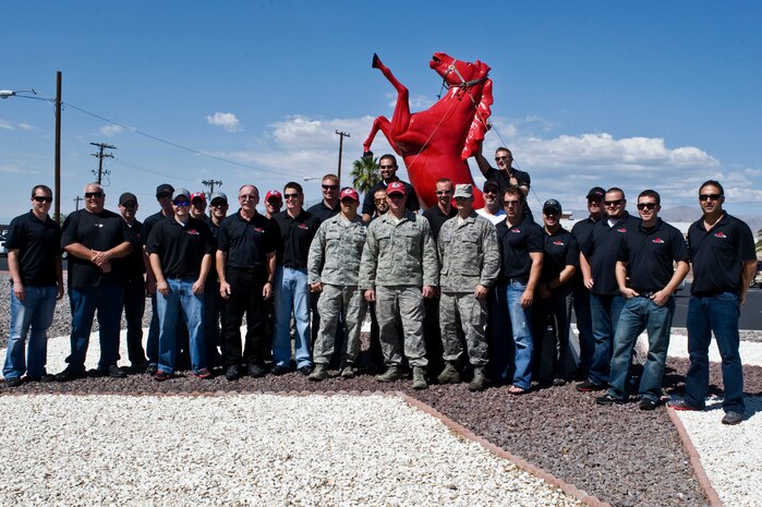 Airmen from the 820th RED HORSE and the Red Horse Racing team pose for a  group photo during the visit to the 820th RED HORSE compound Sept. 27, 2012, at Nellis Air Force Base, Nev. The Red Horse racing team and the 820th RED HORSE created a partnership two years ago. Since then, both have made special efforts to share team building experiences and knowledge of each other's work.  (U.S. Air Force photo by Airman 1st Class Matthew Lancaster)