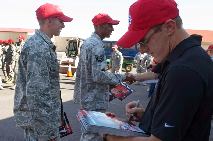 Parker Kligerman, Red Horse Racing driver for the number 7 truck, signs autographs during the visit to the 820th RED HORSE compound Sept. 27, 2012, at Nellis Air Force Base, Nev. Kligerman will be racing in Smith's 350 NASCAR Camping World Truck Series Race, Sept. 29, 2012. (U.S. Air Force photo by Airman 1st Class Matthew Lancaster)