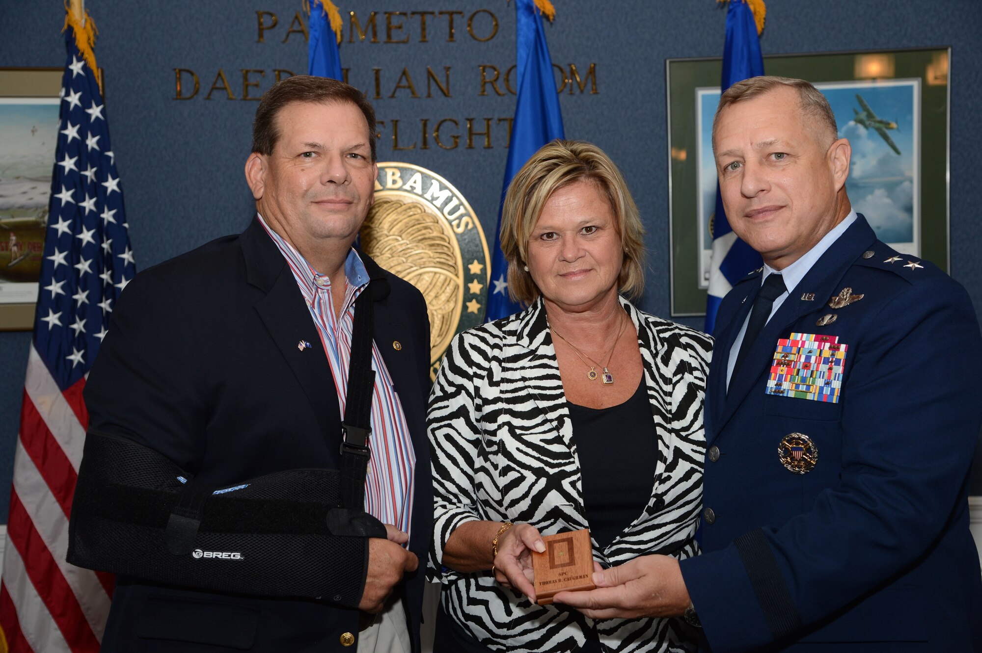 Hampton Caughman and his wife Jane pose for a photo with 9th Air Force Commander, U.S. Air Force Maj. Gen. Lawrence Wells after receiving a plaque with the a Gold Star on it, which is for families that have lost loved ones during a deployment or in combat. Inviting them to a ceremony recognizing their fallen family members honored six Gold star families.   (U.S.  Air Force photo by Master Sgt. Cohen A. Young/Released)