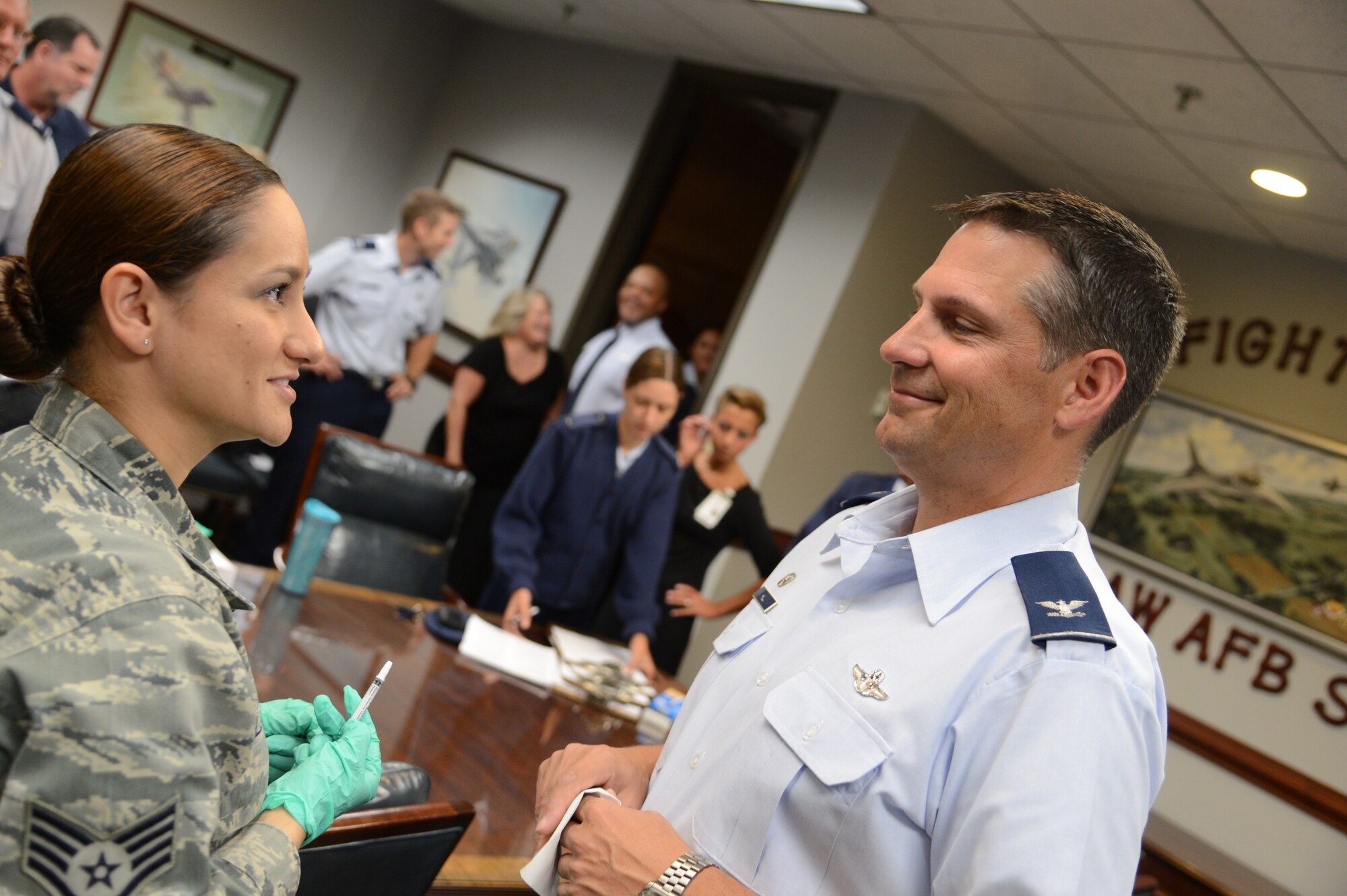 U.S. Air Force Colonel Clay Hall (right), 20th Fighter Wing Commander, Shaw Air Force Base, S.C. speaks with Staff Sgt. Sindy Maldonado, a medical technician assigned to the 20th Medical Group after receiving his flu vaccination here Oct 1, 2012.    (U.S.  Air Force photo by Master Sgt. Cohen A. Young/Released)