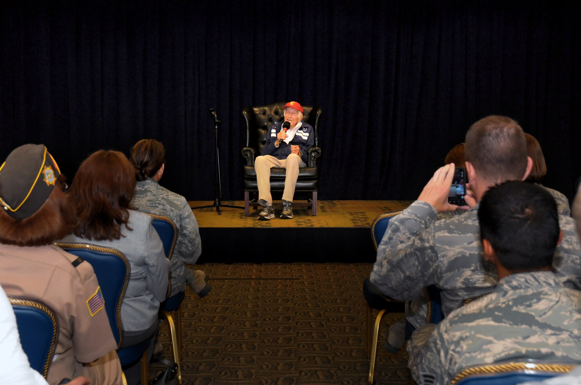 Louis Zamperini tells his story of resiliency to a crowd at the Gordon Conference Center, Sept. 21.  As a child, a police officer suggested he use his fast feet for sport instead of mischief. By the time he graduated from high school, he set the high school world record for running the mile. He was on the 1936 Olympic Team and was the top U.S. finisher in the 5,000 meter run. During World War II, he joined the Army Air Corps and was a bombardier in the South Pacific. On a reconnaissance flight, his plane crashed into the ocean. He and another crew member were adrift in a life raft for 47 days. He was picked up by the Japanese who held him prisoner until the war ended.  (Photo by Joe Juarez)