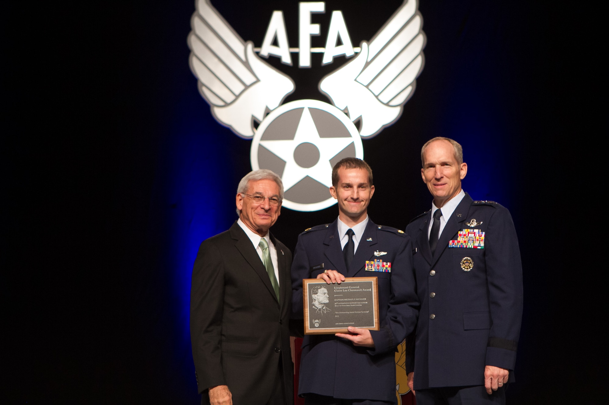 Maj. Mike Richard 20th Operations Support Squadron, (center) receives the  Lt. Gen. Claire Chennault Award at the Air Force Association’s Air and Space Conference and Technology Exposition, Sept. 17, 2012, Washington, D.C. Every year the Air Force spotlights the most outstanding fighter tactician from the combat air forces. The search combs through hundreds of pilots from four major commands, the Air National Guard and Air Force Reserve. This year Richard has been named best combat tactician in the Air Force for 2011, and earned the Lt. Gen. Claire Chennault Award from the Air Force Association. In Operation Odyssey Dawn, the NATO action against Libya, he helped lead the destruction of 101 surface-to-air missiles, 120 radars, 83 missile command vehicles and 120 air defense artillery guns. (Courtesy photo) 