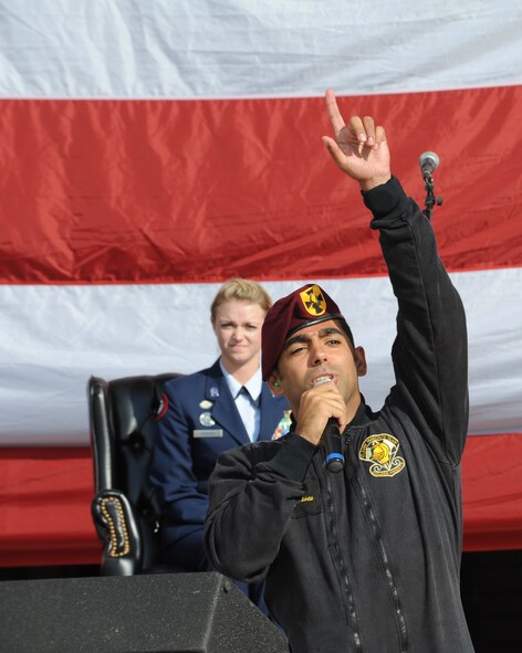 Army Staff Sgt. Kevin Presgraves, U.S. Army Golden Knights Gold Team demonstration member, points to the sky as his fellow demonstration team members begin their show Sept. 28, 2012, McConnell Air Force Base, Kan. Presgraves, the first jumper, narrated their performance as he waited for his teammates to land. (U.S. Air Force photo/Airman 1st Class Victor J. Caputo)