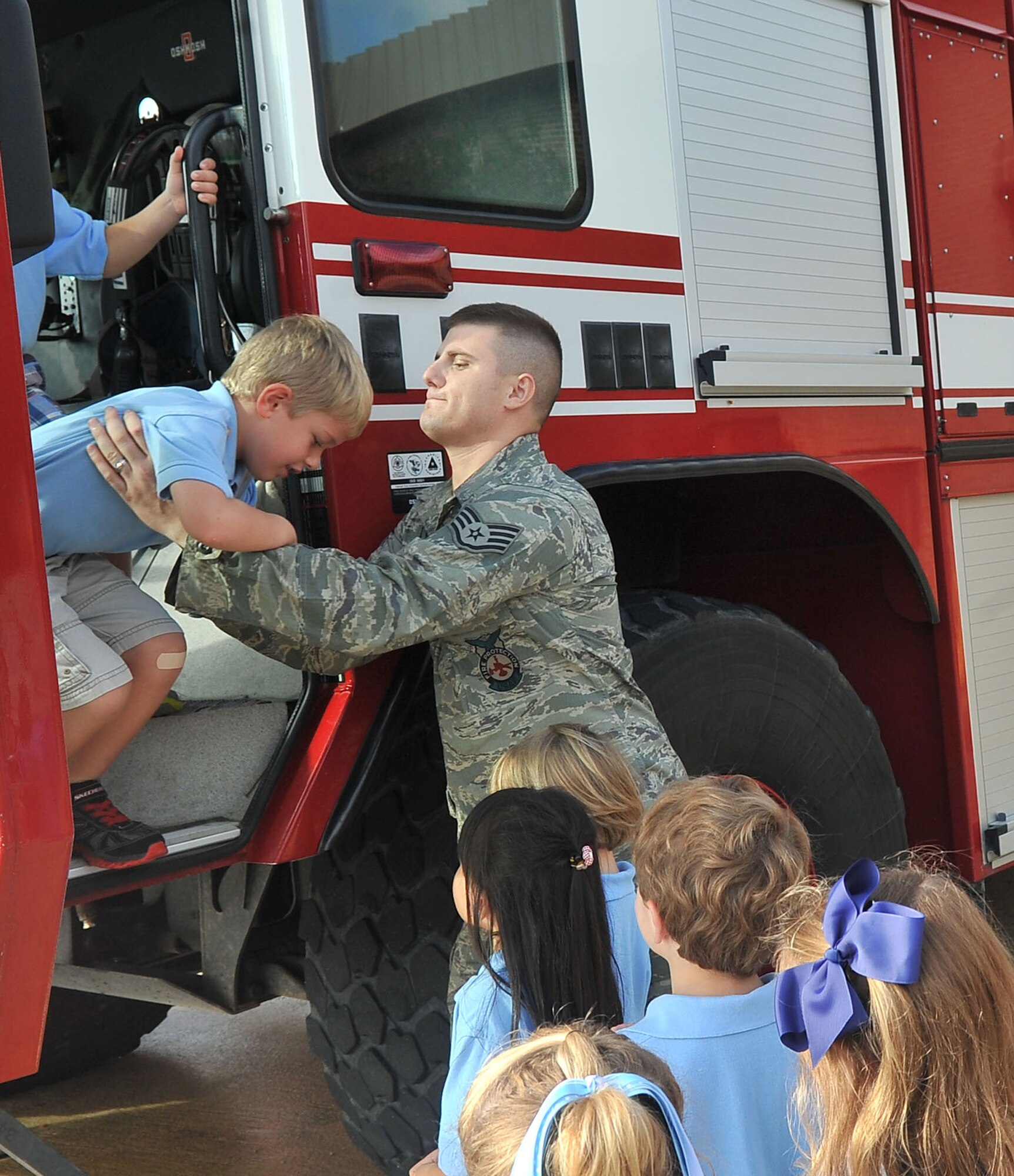 U.S. Air Force Staff Sgt.  Logan Williams, 20th Civil Engineer Squadron firefighter, helps kindergartners off a fire truck during a fire department tour, Shaw Air Force Base, S.C., Oct. 2, 2012.The tour was given to children from Wilson Hall as October is fire prevention month. (U.S. Air Force photo by Airman 1st Class Ashley L. Gardner/ Released)