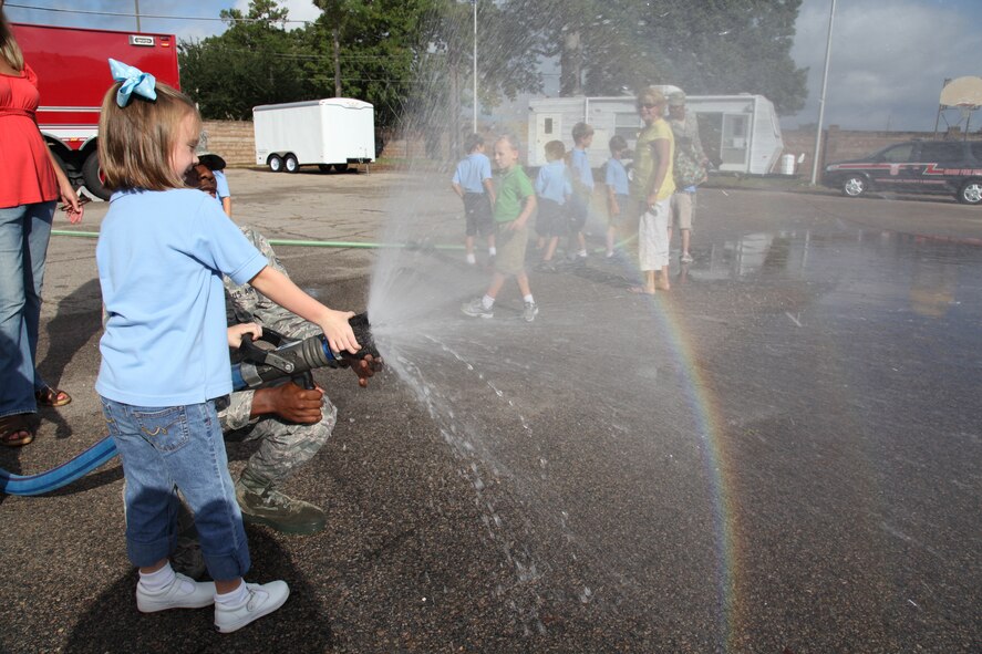 Lucy Buxton, Wilson Hall student, sprays a fire hose at the base fire station. The Shaw Air Force Base fire department welcomed 60 Wilson Hall kindergartners for a tour Oct. 2, 2012.  (U.S. Air Force photo by 1st Lt. Ann Blodzinski)