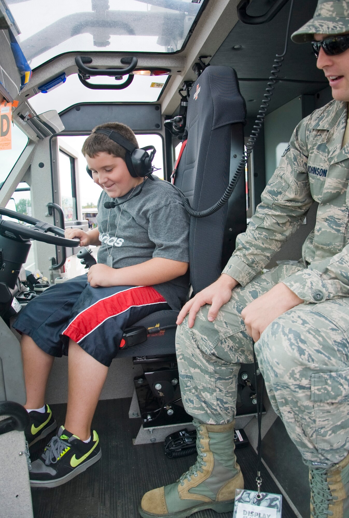 Zachary Fee, left, sounds the horn in a fire truck Sept. 29, 2012, at the Monster Fun Zone at Dover International Speedway in Dover, Del. Airman 1st Class Matthew Johnson, right, a firefighter with the 436th Civil Engineer Squadron, was one of the Team Dover members who brought the truck to the track for the enjoyment of community members. (U.S. Air Force photo by Airman 1st Class Samuel Taylor)