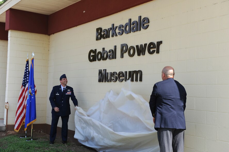 Col. Andrew Gebara, 2nd Bomb Wing commander, and Terri Snook, 8th Air Force Museum Association president, pull a tarp down to reveal the new name of the 8 AF Museum on Barksdale Air Force Base, La., Oct. 2. The museum's new name is the Barksdale Global Power Museum. Currently, the museum is ranked third for the most visited attraction in the Shreveport/Bossier area by receiving 50,000 visitors a year. (U.S. Air Force photo/Senior Airman Micaiah Anthony)(RELEASED)