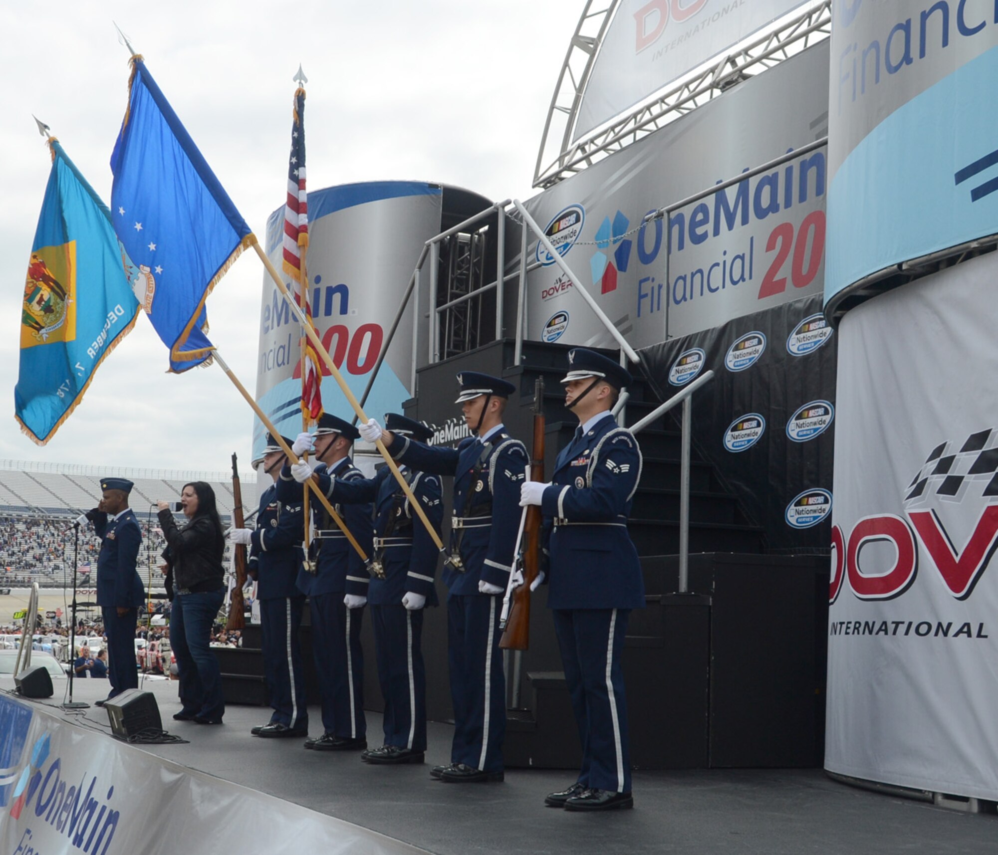 Maj. Barry Ingram, left, 512th Airlift Wing chaplain, and members of the Team Dover Honor Guard render honors as national recording artist Gina Zavalis sings the National Anthem before the start of the NASCAR Nationwide Series One Main Financial 200 Sept. 29, 2012, at Dover International Speedway in Dover, Del. (U.S. Air Force photo by Tech. Sgt. Chuck Walker)