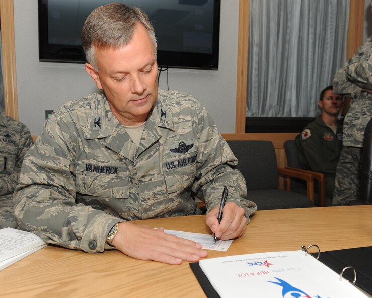 Air Force Col. Glen VanHerck, 7th Bomb Wing commander, completes his Combined Federal Campaign pledge form Sept. 28, 2012, at Dyess Air Force Base, Texas. Coming off their best year since 2006, Team Dyess is trying to have another good year by raising at least $165,000 and have a wing participation goal of at least 30 percent in this year’s CFC. (U.S. Air Force photo by Senior Airman Joel Mease/ Released) 