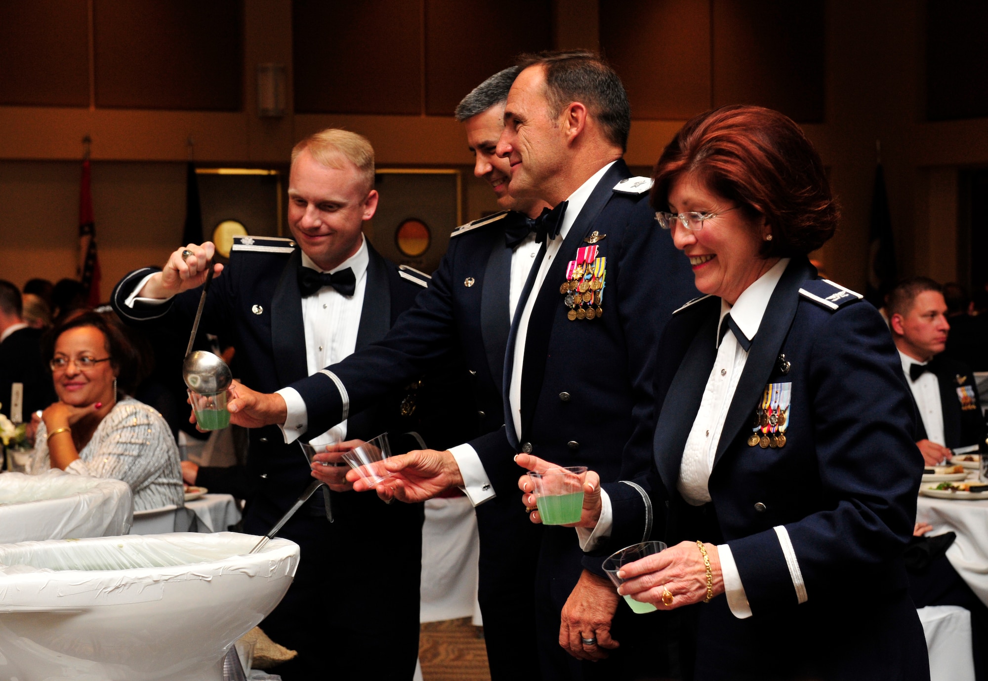 BUCKLEY AIR FORCE BASE, Colo. – Team Buckley members gather for a drink out of the grog bowl during a dining out Sept. 28, 2012, in the Leadership Development Center. Donning ones best Air Force attire, drinking from grog bowls and following rules of the mess are all time-honored traditions of the dining out. (U.S. Air Force photo by Airman 1st Class Darryl Bolden Jr.)