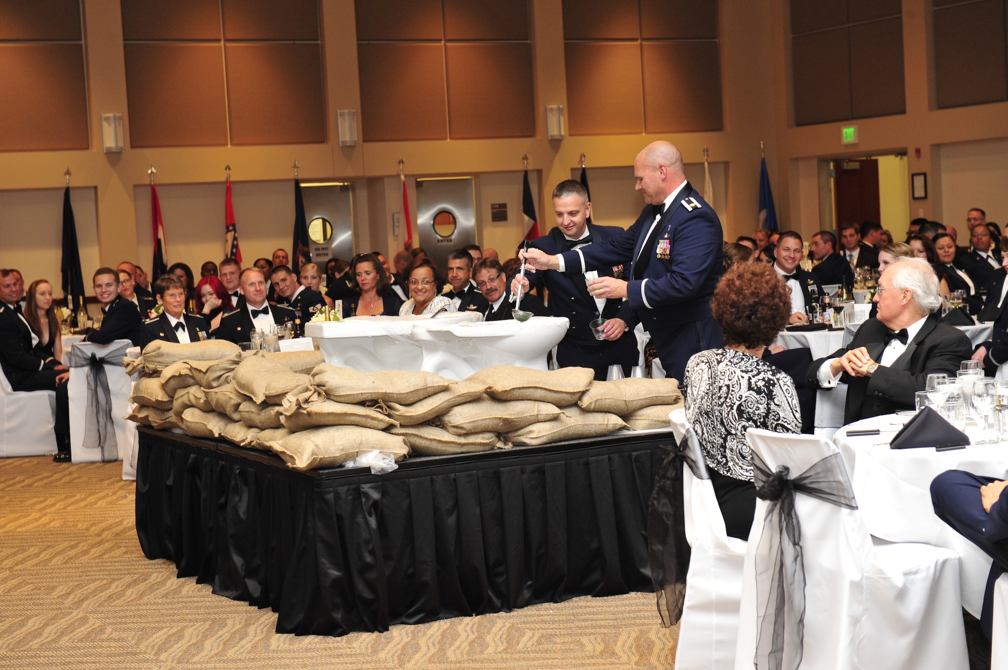 BUCKLEY AIR FORCE BASE, Colo. – Chief Master Sgt. William Ward, 460th Space Wing command chief, and Chaplain (Maj.) Gary Coburn are requested by Col. Daniel Dant, 460th SW commander, to drink from the grog bowl during a dining out Sept. 28, 2012, in the Leadership Development Center. The first dining outs, called "wingdings," were organized by Gen. Henry 'Hap' Arnold, an Air Force pioneer. (U.S. Air Force photo by Airman 1st Class Darryl Bolden Jr.)