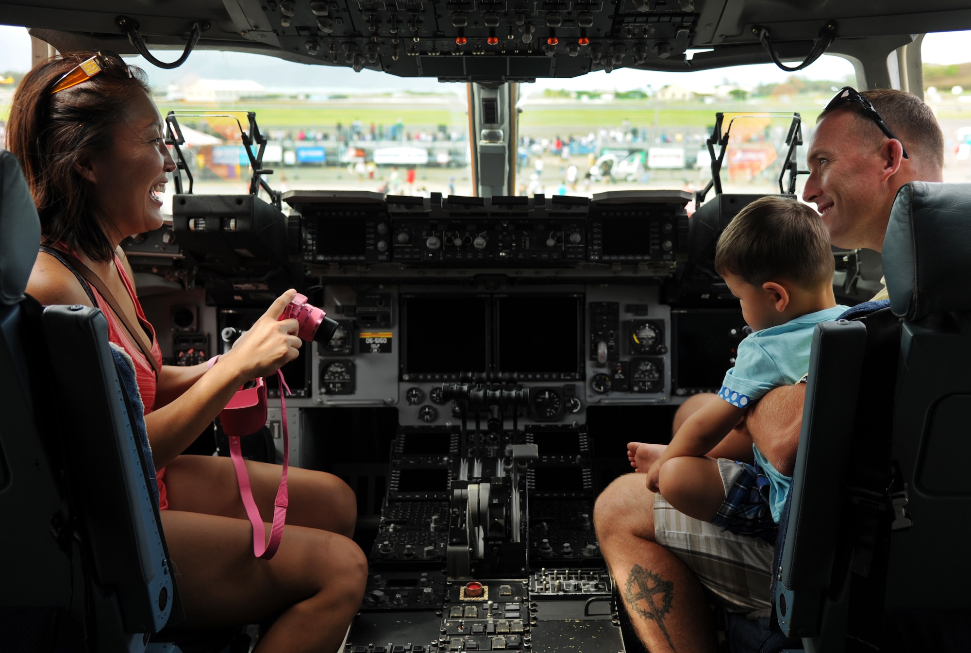 U.S. Marine Corps Staff Sgt. Michael Edwards, with his wife and son, tour the static C-17 Globemaster III at the Kaneohe Bay Airshow on Marine Corps Base Hawaii, Sept. 29. The Pacific Air Forces C-17 demonstration team flew a 12-minute long demo which showcased the capabilities of the aircraft. (U.S. Air Force photo/Senior Airman Lauren Main)