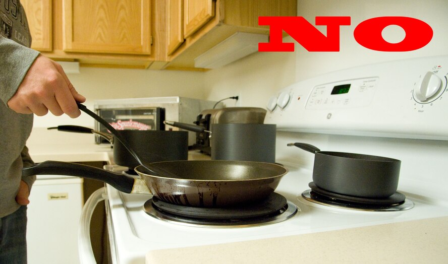 Staff Sgt. Robert Russell demonstrates improper cooking techniques Oct. 1, 2012, at Dover Air Force Base, Del. The National Fire Protection Association urges residents to turn stove handles away from them so children cannot reach the handles, and to never leave cooking unattended. The leading cause of fires in the kitchen is unattended cooking. (U.S. Air Force photo illustration by Adrian R. Rowan)