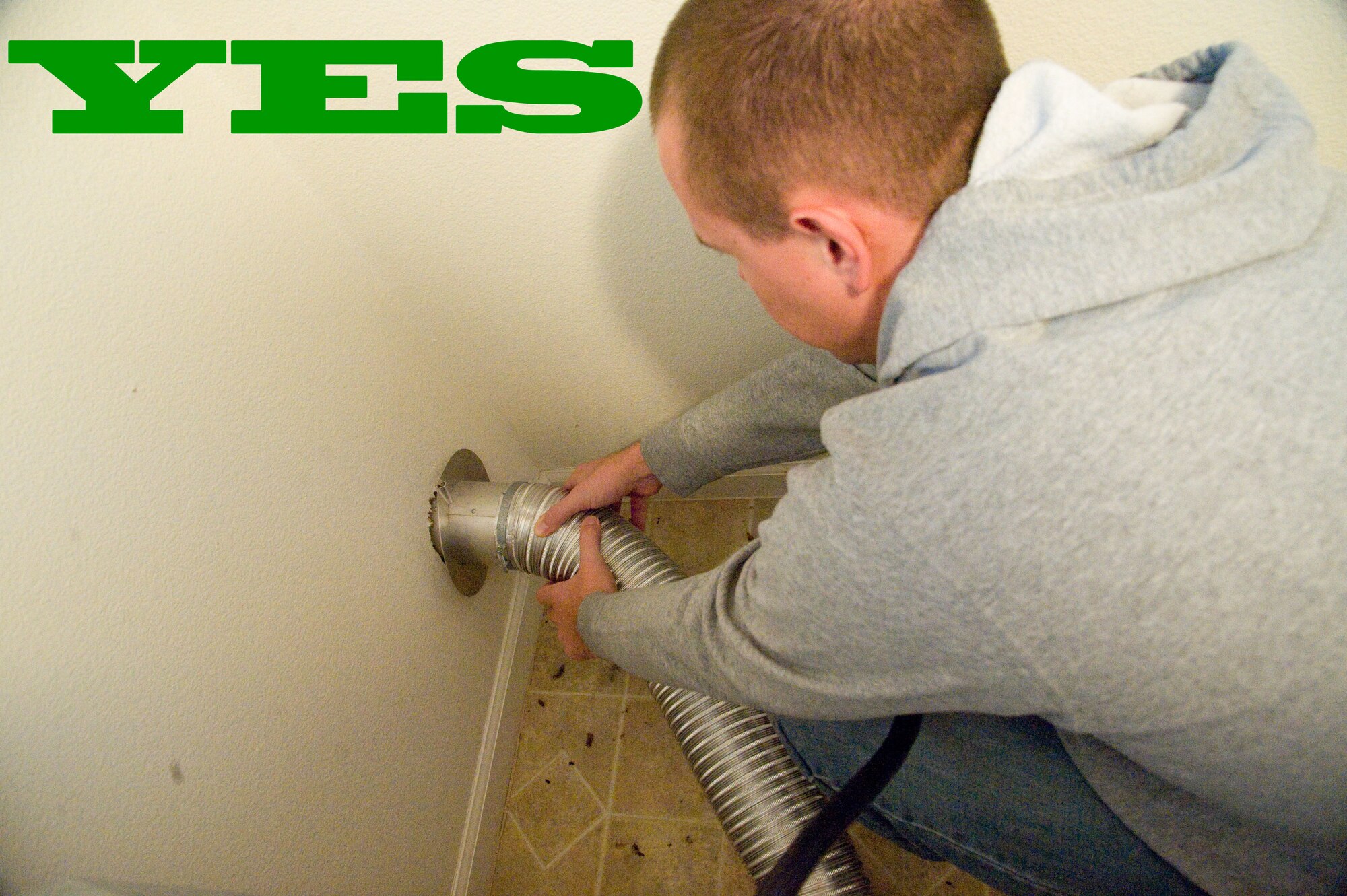 Staff Sgt. Robert Russell demonstrates how to clean lint out of a dryer vent pipe Oct. 1, 2012, at Dover Air Force Base, Del. The National Fire Protection Association urges residents to clean lint out of the vent pipe yearly, or more often if clothes are taking longer than normal to dry. (U.S. Air Force photo illustration by Adrian R. Rowan)