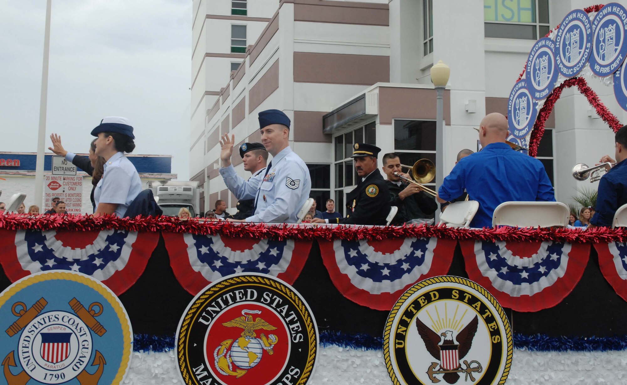 The Neptune Festival Hometown Heroes acknowledge the cheers of onlookers during the Neptune Festival Grand Parade Sept. 29, 2012, at Virginia Beach, Va. One Service member from each branch of the military was selected to ride on the Hometown Heroes float. (U.S. Air Force photo by Airman 1st Class Austin Harvill/Released)