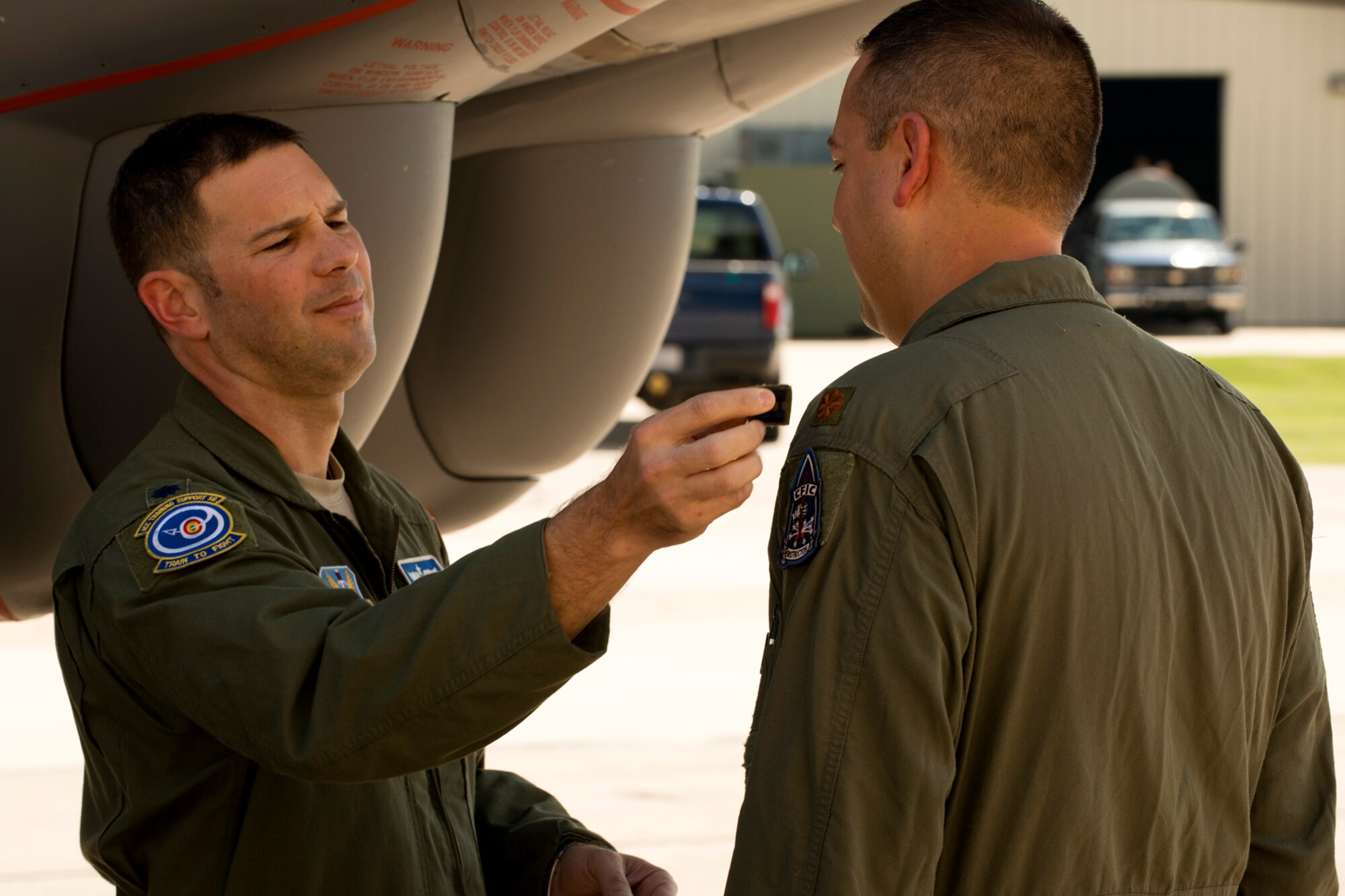 U.S. Air Force Lt. Col. Robert Bender removes the Captains rank insignia from the shoulder of Maj. Brian Heck during a Pinning On ceremony, Sept. 28, 2012, Barksdale Air Force Base, La. Heck was recently promoted to the rank of Major and is assigned to the 11th Bomb Squadron at Barksdale. (U.S. Air Force photo by Master Sgt. Greg Steele/Released)