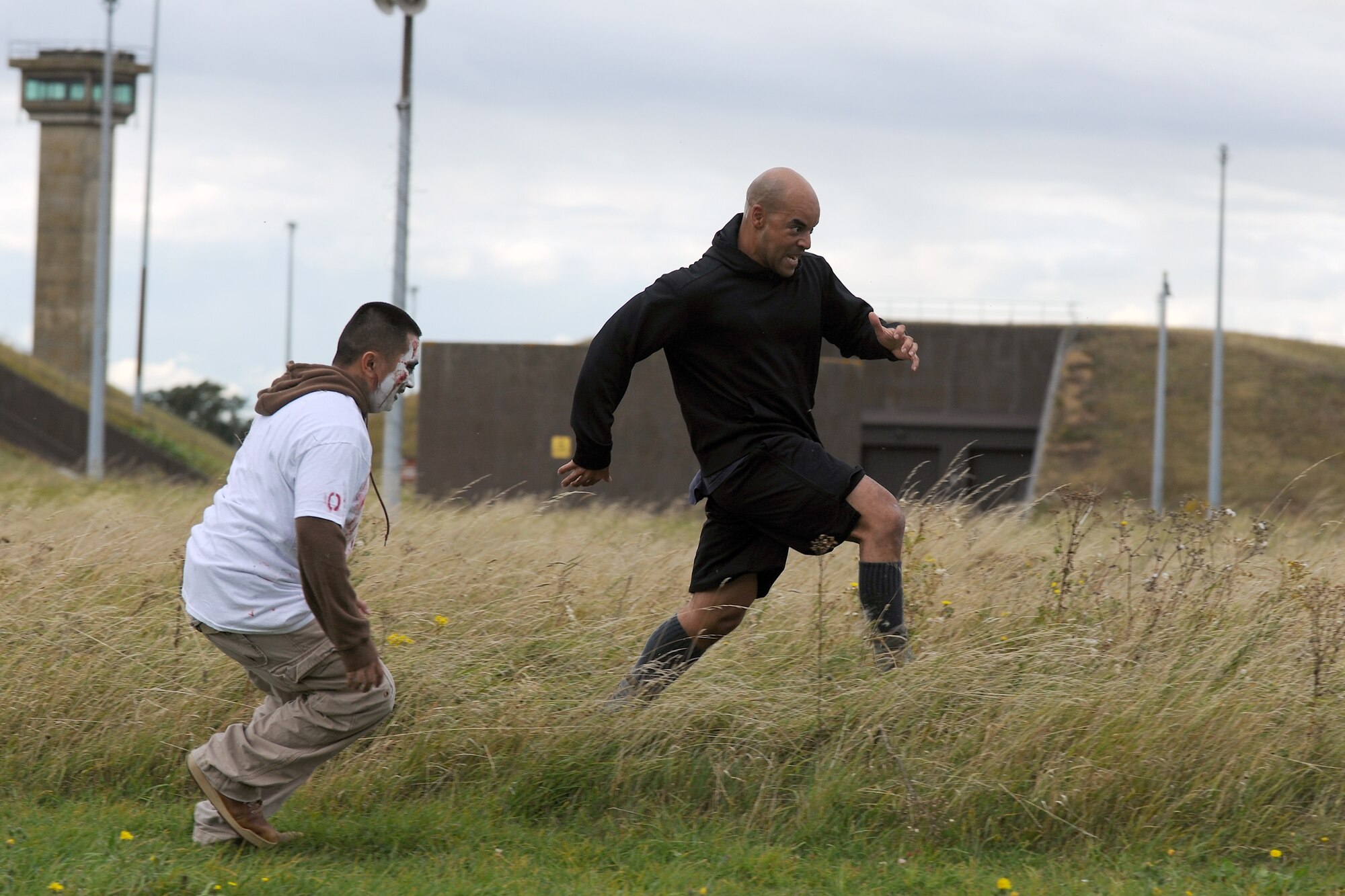 RAF MOLESWORTH, United Kingdom – Raymond Cummings escapes from a zombie through tall grass at the finish line of the Zombie Survival 5K Run held by the 501st Combat Support Wing Emergency Management Flight Sept. 28 on RAF Molesworth, United Kingdom. The run was held in support of National Preparedness Month (U.S. Air Force photo by Master Sgt. John Barton)