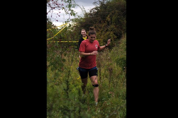 RAF MOLESWORTH, United Kingdom –Jessica Lubold and Bridgett Young run through high grass after escaping from zombies in a village during the Zombie Survival 5K Run held by the 501st Combat Support Wing Emergency Management Flight Sept. 28 on RAF Molesworth, United Kingdom. The run was held in support of National Preparedness Month. (U.S. Air Force photo by Staff Sgt. Brian Stives)