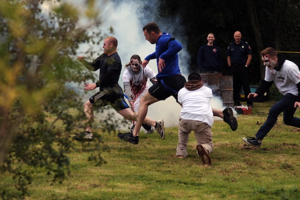 RAF MOLESWORTH, United Kingdom –Members of the 501st Combat Support Wing are chased by zombies through a village during the Zombie Survival 5K Run held by the 501st Combat Support Wing Emergency Management Flight Sept. 28 on RAF Molesworth, United Kingdom. The run was held in support of National Preparedness Month. (U.S. Air Force photo by Staff Sgt. Brian Stives)