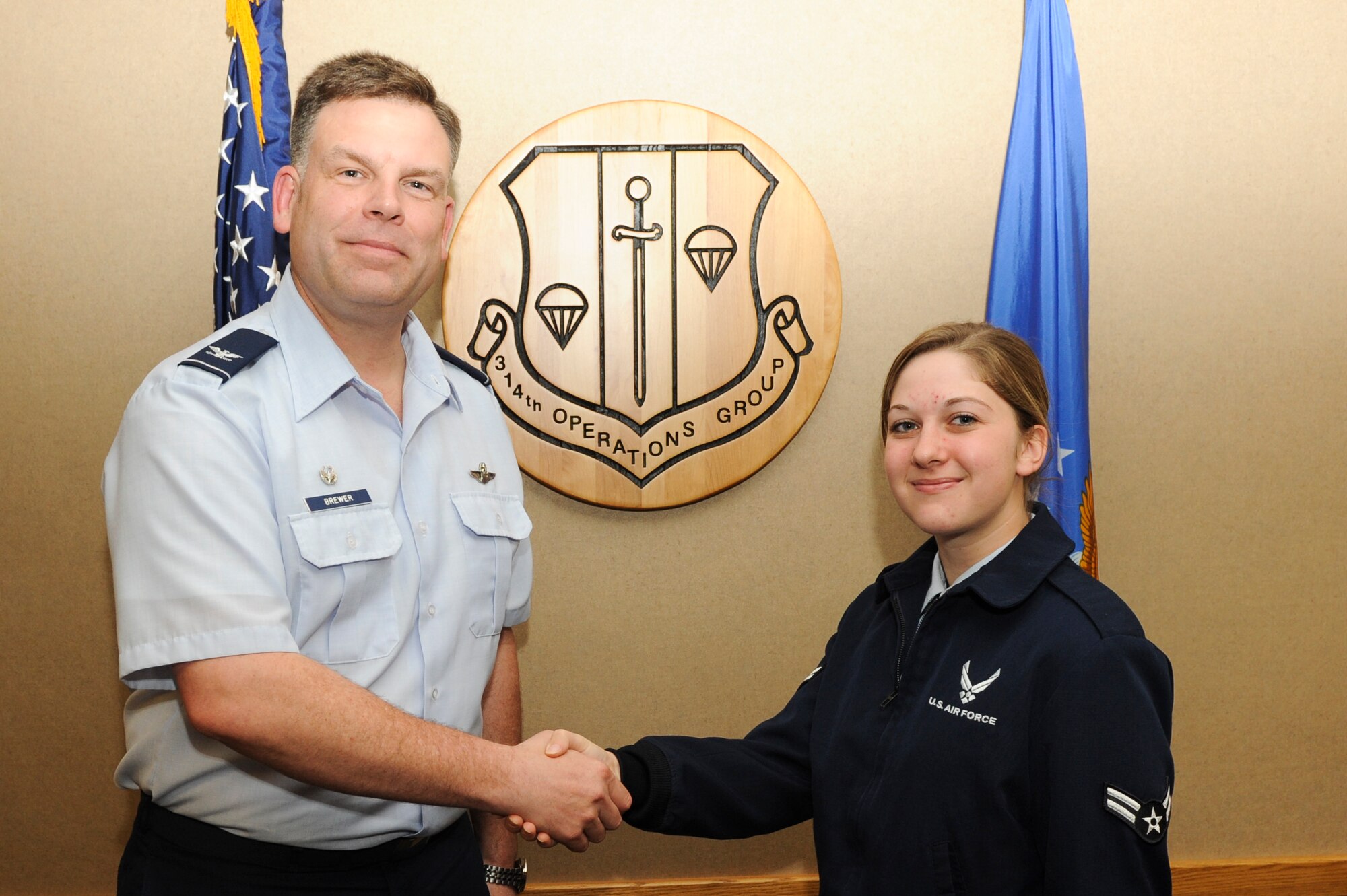 Col. Scott Brewer, 314th Airlift Wing commander, congratulates Airman 1st Class Brooke Savage, a 314th Operations Group knowledge operation apprentice, for her selection as the Combat Airlifter of the week Oct. 1, 2012, at Little Rock Air Force Base, Ark. Savage, a Whitehouse, Ohio native, worked eight hours during the 2012 Heritage and Heroes Open House and Airshow helping the Little Rock Rising Six raise more than $10,000. (U.S. Air Force photo by Airman 1st Class Rusty Frank)