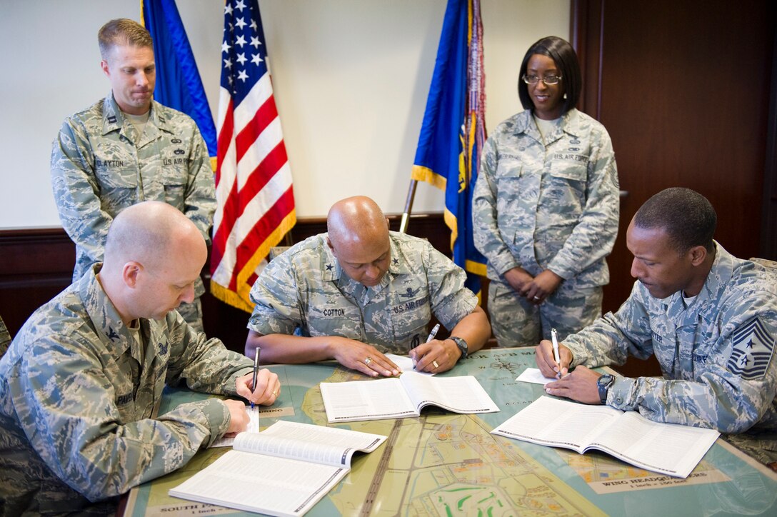 Brig. Gen. Anthony Cotton, center, commander, 45th Space Wing, Col. Robert
Pavelko, left, vice commander, 45th Space wing, and Chief Master Sgt. Herman
Moyer, 45th Space Wing command chief, sign the forms for this year's
Combined Federal Campaign. The campaign opened Monday and will run through
Oct. 31. Our team goal this year is $200,000. Also pictured are Capt. Billy
Clayton, standing left, and Senior Master Sgt. Marcia Scantlebury Hall, both
from the 45th Force Support Squadron, who are "CFC Key Persons" for the
campaign. Photo by Julie Dayringer. 
