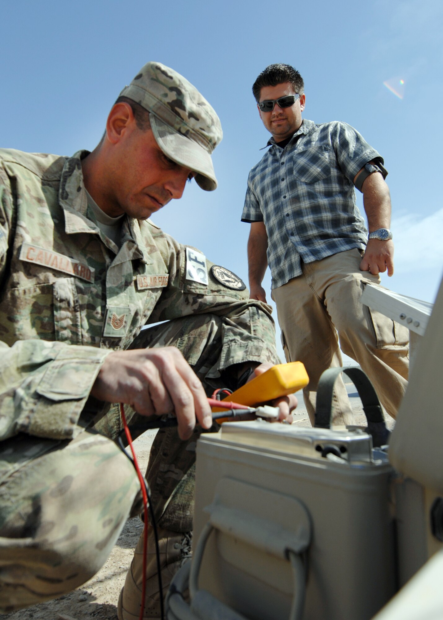 U.S. Air Force Tech Sgt. Joseph Cavallaro and Chris Zapata, 451st Expeditionary Security Forces Squadron tactical automated security systems, check battery voltage on a rechargeable battery module. The modules power the sensors around KAF. (U.S. Air Force photo/Master Sgt. Russell Martin/RELEASED)