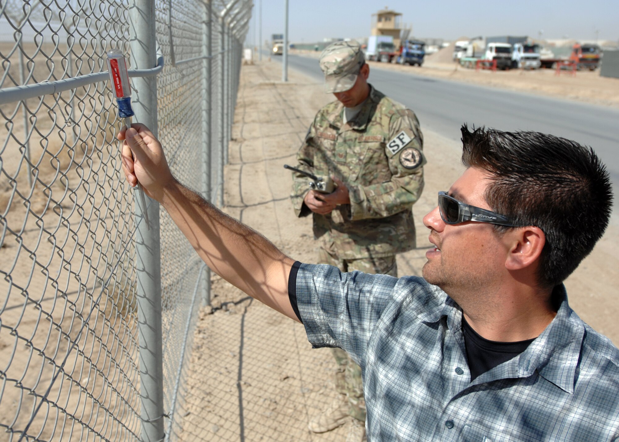 U.S. Air Force Tech Sgt. Joseph Cavallaro and Chris Zapata, 451st Expeditionary Security Forces Squadron tactical automated security systems, induce a system alert to check the sensitivity of the security sensors around the perimeter. (U.S. Air Force photo/Master Sgt. Russell Martin/RELEASED)