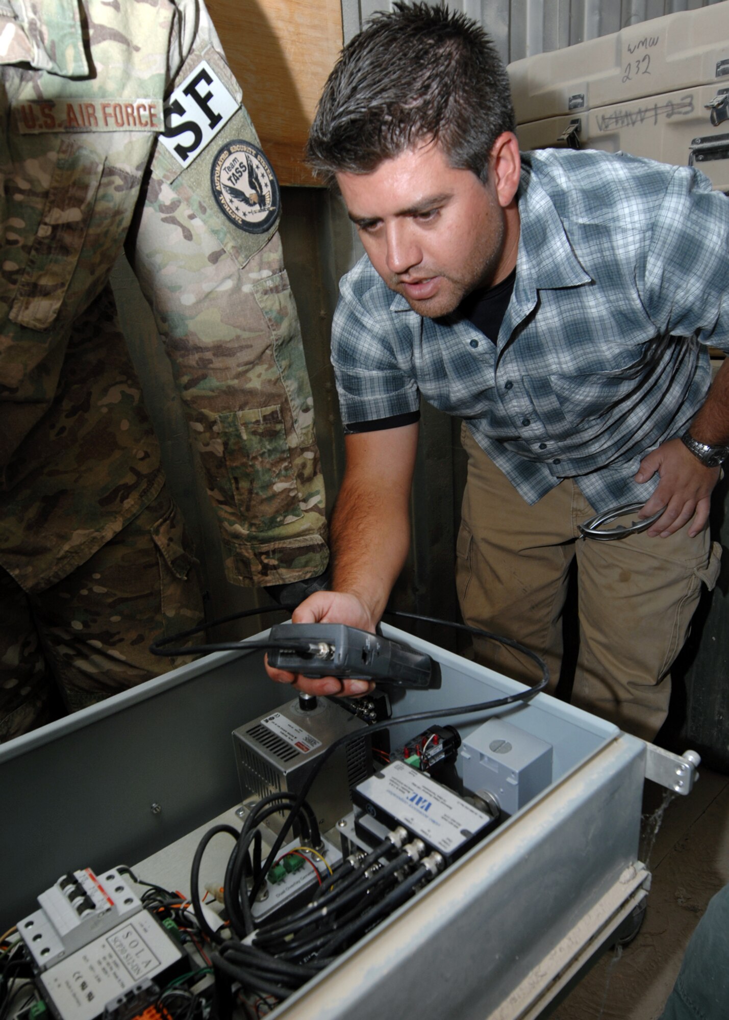 Chris Zapata, 451st Expeditionary Security Forces Squadron tactical automated security system engineer, verifies a signal is running to the video feed of a long range thermal imager at KAF. (U.S. Air Force photo/Master Sgt. Russell Martin/RELEASED)