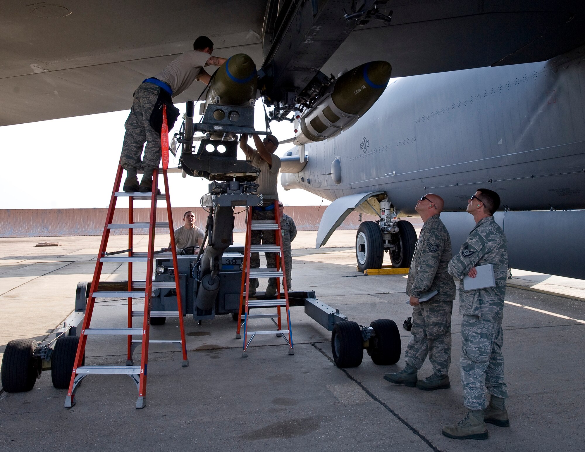 Airmen from the 20th Aircraft Maintenance Unit Viper 1 load crew mount an inert two-thousand pound GBU-31 bomb to a B-52H Stratofortress in front of evaluators on Barksdale Air Force Base, La., Sept. 28. The bomb load was part of a competition between load crews from the 20th AMU and 96th AMU. (U.S. Air Force photo/Staff Sgt. Chad Warren)(RELEASED)

