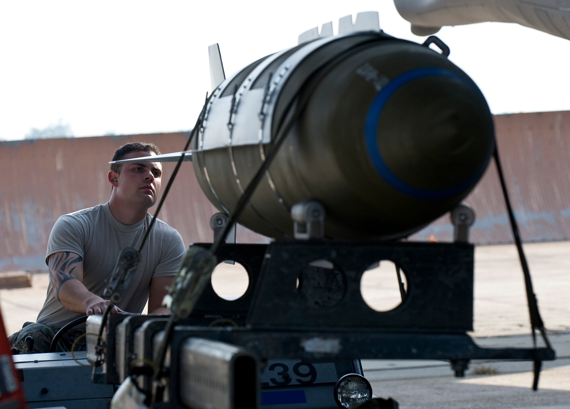 Senior Airman Devin Borger, 20th Aircraft Maintenance Unit Viper 1 Load Crew member, lifts an inert two-thousand pound GBU-31 bomb into position under the wing of a B-52H Stratofortress during a competition on Barksdale Air Force Base, La., Sept. 28. The four-person crew loaded two bombs during the competition, which pitted load crews from the 20th AMU and 96th AMU against each other to determine which team is most efficient. (U.S. Air Force photo/Staff Sgt. Chad Warren)(RELEASED)
