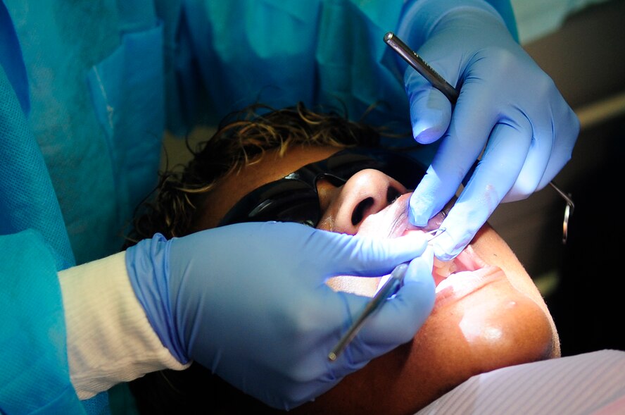U.S. Air Force Capt. Jennilyn Estell, 20th Dental Squadron doctor of medical dentistry, begins to clean the teeth of the patient, Tanya Maisonet, during a training exercise for the Red Cross Volunteer Dental Assistance Program, Shaw Air Force Base, S.C., Sept. 24, 2012. The Red Cross Dental Assistance Program offers dental education to military dependents and spouses, with over 900 hours of both classroom and hands-on training. (U.S. Air Force photo by Airman Hunter Brady/Released) 