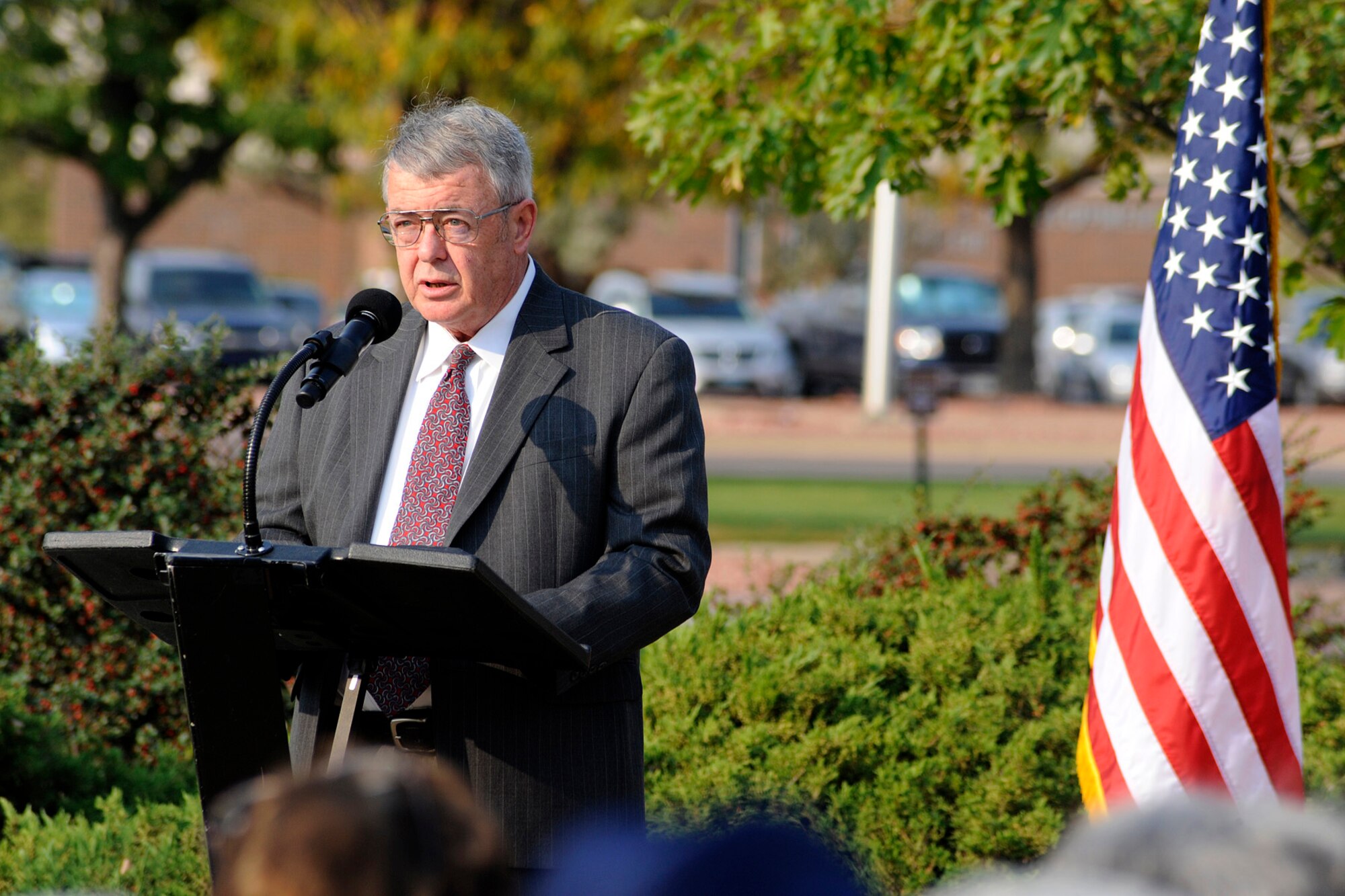 Dennis McCormack, retired Army Chief Warrant Officer 5, speaks to an audience during POW/MIA Recognition Day Sept. 21. McCormack spoke about the resolve of the United States to account for the more than 83,000 American servicemembers who have been listed as missing since World War II. (U.S. Air Force photo/Rob Bussard). 