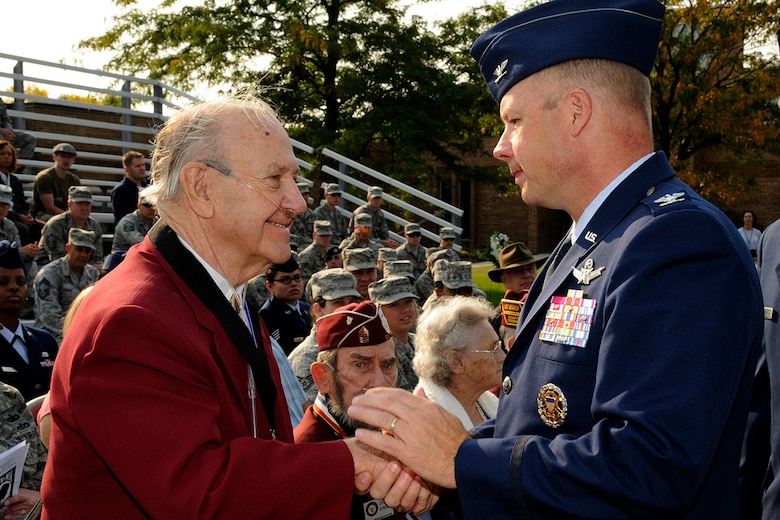 Col. Chris Crawford, 21st Space Wing commander, presents a medal to Charles Blaney, a World War II Prisoner of War, during the POW/MIA Recognition Day ceremony Sept. 21. Blaney was one of three POWs who was celebrated during the ceremony. (U.S. Air Force photo/Rob Bussard)