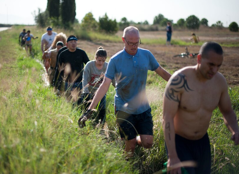 Participants walk through a ditch during the Ultimate Dirty Dash II Sept. 29, 2012, at Incirlik Air Base, Turkey. The event was hosted by Incirlik's Top 3 to promote fitness and camaraderie, and to give the base community a chance to socialize and have fun. (U.S. Air Force photo by Senior Airman Clayton Lenhardt/Released)
