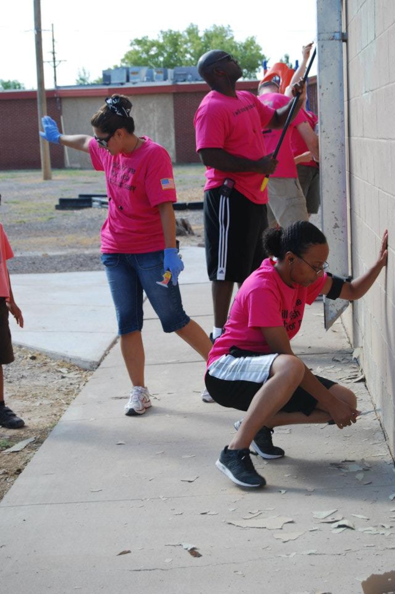 (Left to right) Staff Sgt. Kelly Bender, Capt. William Prescott, and Staff Sgt. Talanna Fisher, 4th Space Control Squadron, scrape paint at the Holloman AFB middle school. The 4th SPCS Pirates spent 858 volunteer hours over three weeks painting the school, part of a volunteer program at the base. The 4th SPCS is one of the 21st Space Wing’s many geographically separated units, and provides offensive counterspace and space situational awareness to defend space assets. (U.S. Air Force photo)