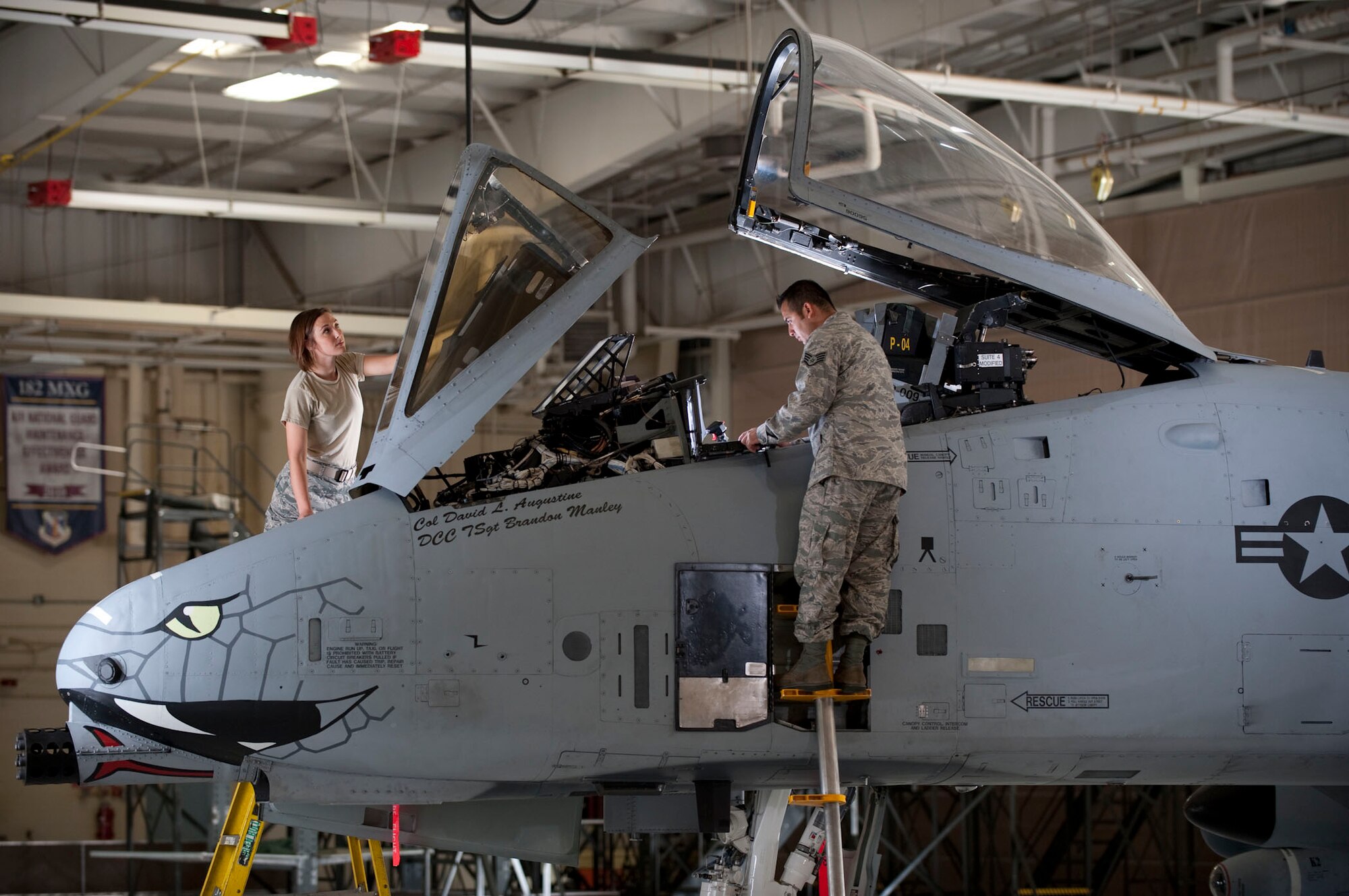 Two airmen simulate performing checks on an A-10 aircraft during an Air National Guard commercial shoot September 28, 2012 in Peoria, Ill.