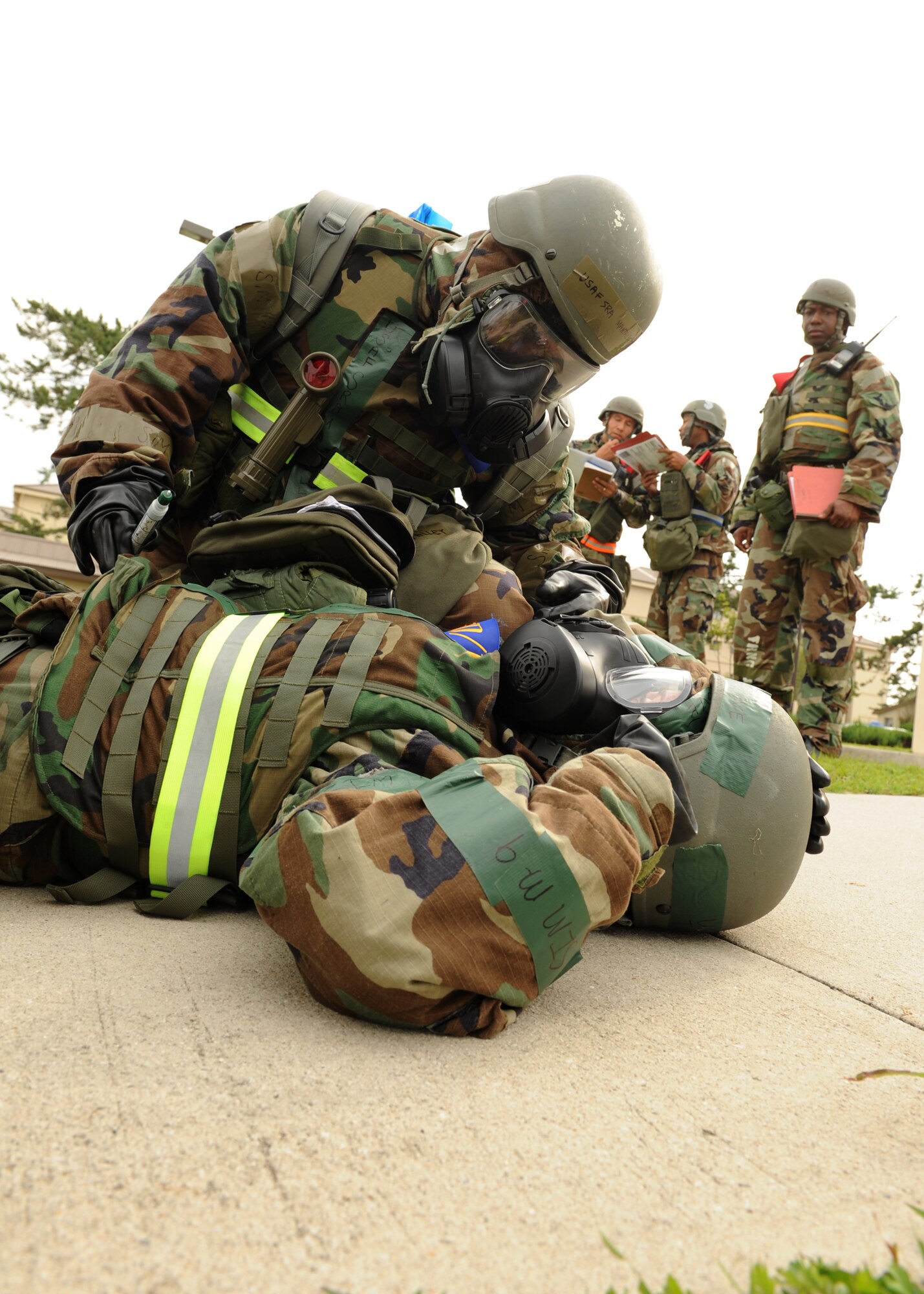 Senior Airman Mantalley Talley, 8th Force Support Squadron, checks the status of Tech. Sgt. Tracy Love, 8th FSS, while Exercise Evaluation Team members observe during exercise Beverly Midnight 12-4 on Kunsan Air Base, Republic of Korea, Sept. 27, 2012. EET members evaluate military members during exercises and ensure they respond appropriately to various scenarios such as wounds, chemical contamination and ground attacks. (U.S. Air Force photo/Staff Sgt. Jonathan Fowler)