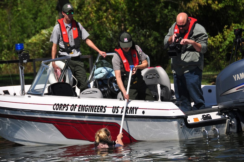 Old Hickory Park Rangers Amy Redmond (middle), Kathryn Wall (in water), Noel Smith (left), and Senior Multimedia Design Engineer Richard Scott (right) work on the “reach” section of the educational video Sept. 27, 2011 titled “Reach, Throw, Row, but Don’t Go.” (USACE photo by John Baird)