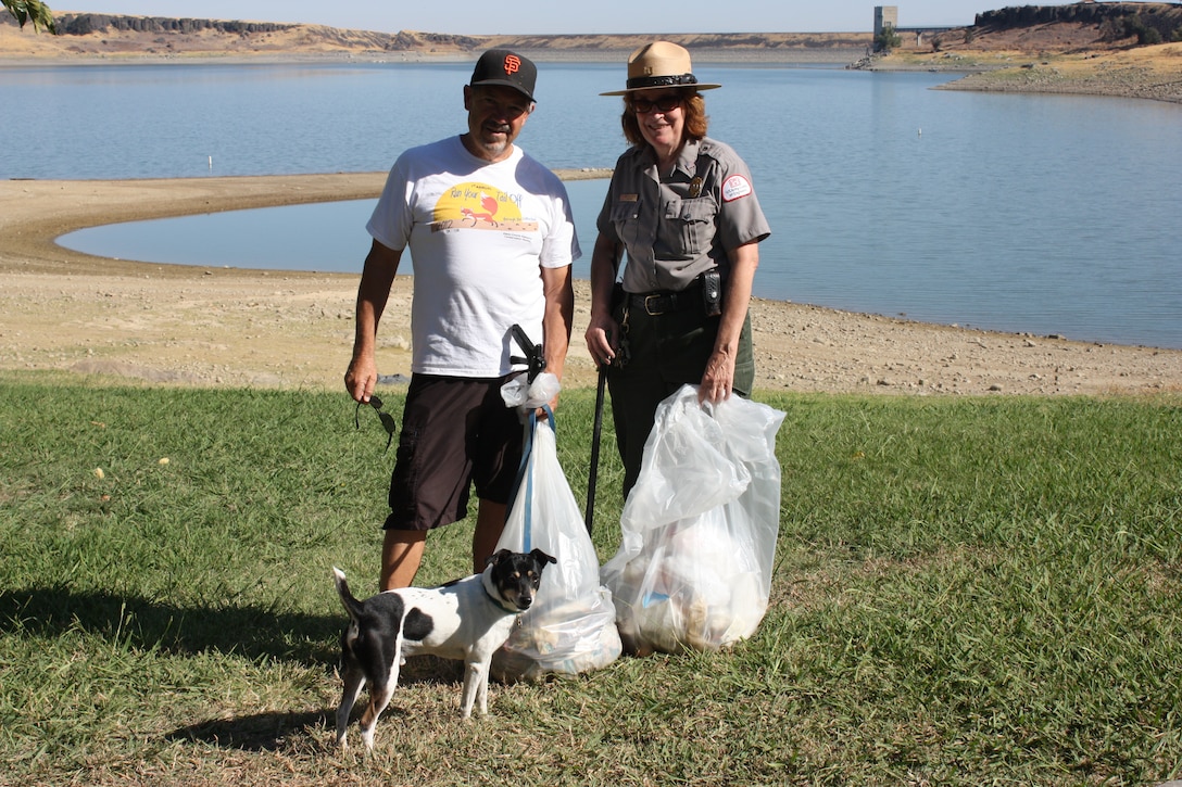 Park Ranger Mary Ann Deeming, Orland City Council Member Bruce Roundy and dog Will pause for a minute before returning to litter removal duties.  Five miles of Black Butte Lake shoreline was cleaned by the community on National Public Lands Day, Sept. 29, 2012.