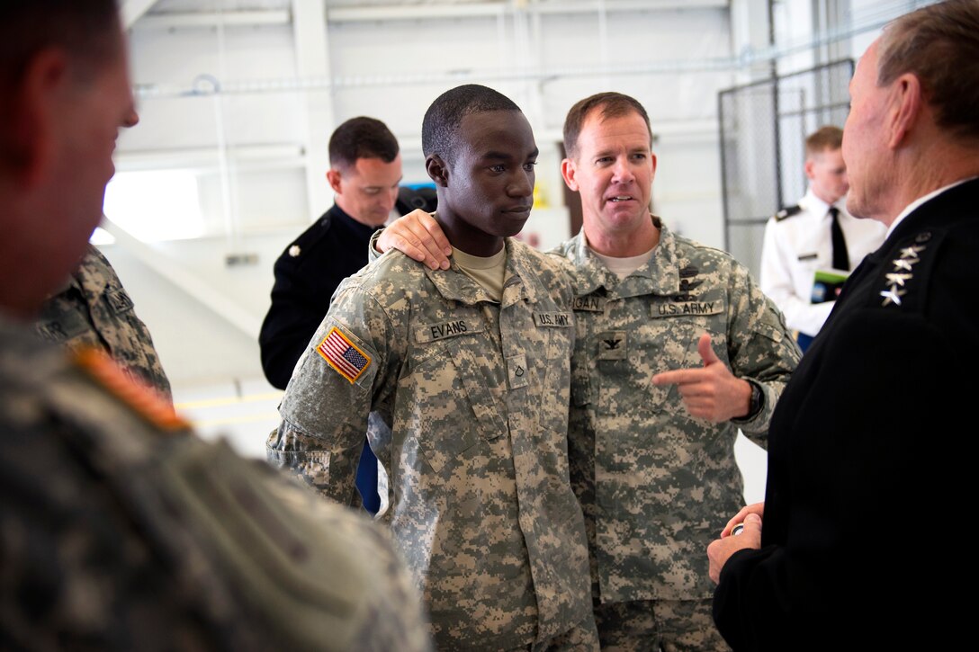 Army Col. John M. Morgan introduces Pfc. Evans to Army Gen. Martin E. Dempsey, chairman of the Joint Chiefs of Staff, during a briefing on the capabilities of the Gray Eagle Unmanned Aerial Vehicle and the AH-64D Apache Longbow Block III helicopter on Fort Riley, Kan., Oct. 1, 2012. Morgan is the commander of the 1st Infantry Division's Combat Aviation Brigade. 