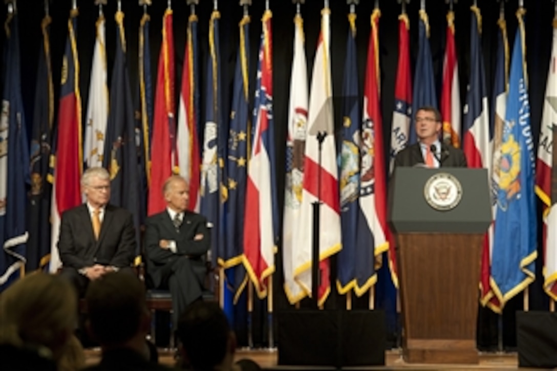 Deputy Secretary of Defense Ashton Carter addresses the audience at a transition ceremony for the Mine Resistant Ambush Protected (MRAP) vehicles program at the Pentagon on Oct. 1, 2012.  Vice President Joseph Biden, center, and Executive Director of the MRAP Task Force Al Shaffer joined Carter on the stage to mark the start of the transition of the MRAP Joint Program Office from the Marine Corps to the Army and the formal establishment of an MRAP Program of Record within each service.  