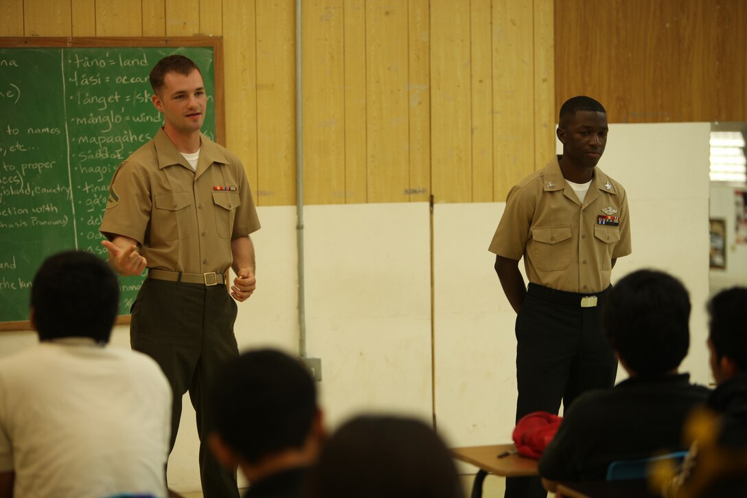 Lance Cpl. Zachary Palmer (left), chemical, biological, radiological and nuclear defense specialist with Combat Logistics Battalion 31, 31st Marine Expeditionary Unit and a native of Shooter, Ill., and Petty Officer 2nd Class Johnnie Howard, religious programs specialist with the 31st MEU and a native of Winterhave, Fla., speak to students of the Simon Sanchez High School during the 31st MEU and USS Bonhomme Richard port visit here, Sept. 28. The Marines and Sailors traded their last day of liberty in Guam to visit the high school and speak about the advantages of military life and the value of an education. The 31st MEU is the only continuously forward-deployed MEU and is the Marine Corps' force in readiness in the Asia-Pacific region.