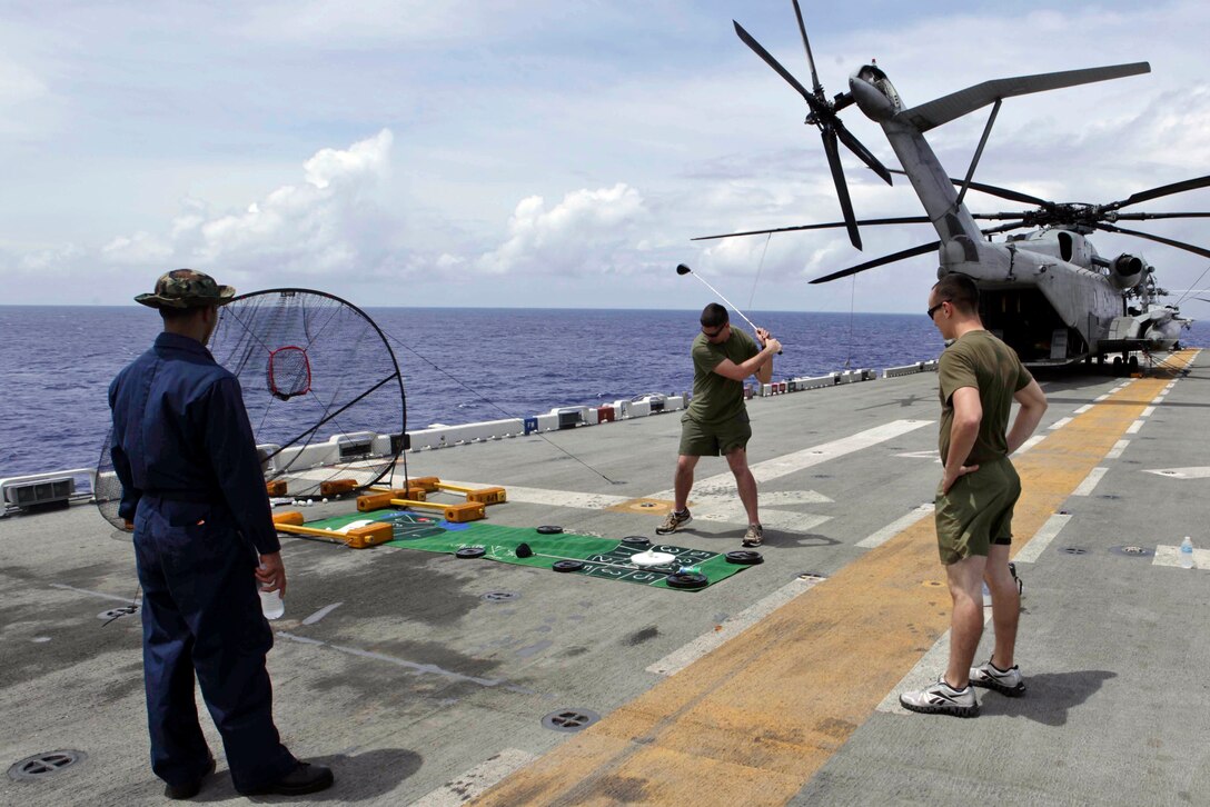 Marines and Sailors with the 31st Marine Expeditionary Unit and the ship's crew of the USS Bonhomme Richard drive golf balls during a steel beach picnic here, Sept. 30. The four-hour event on the flight deck featured fresh barbecue, cold drinks, assorted games, and fitness competitions. 