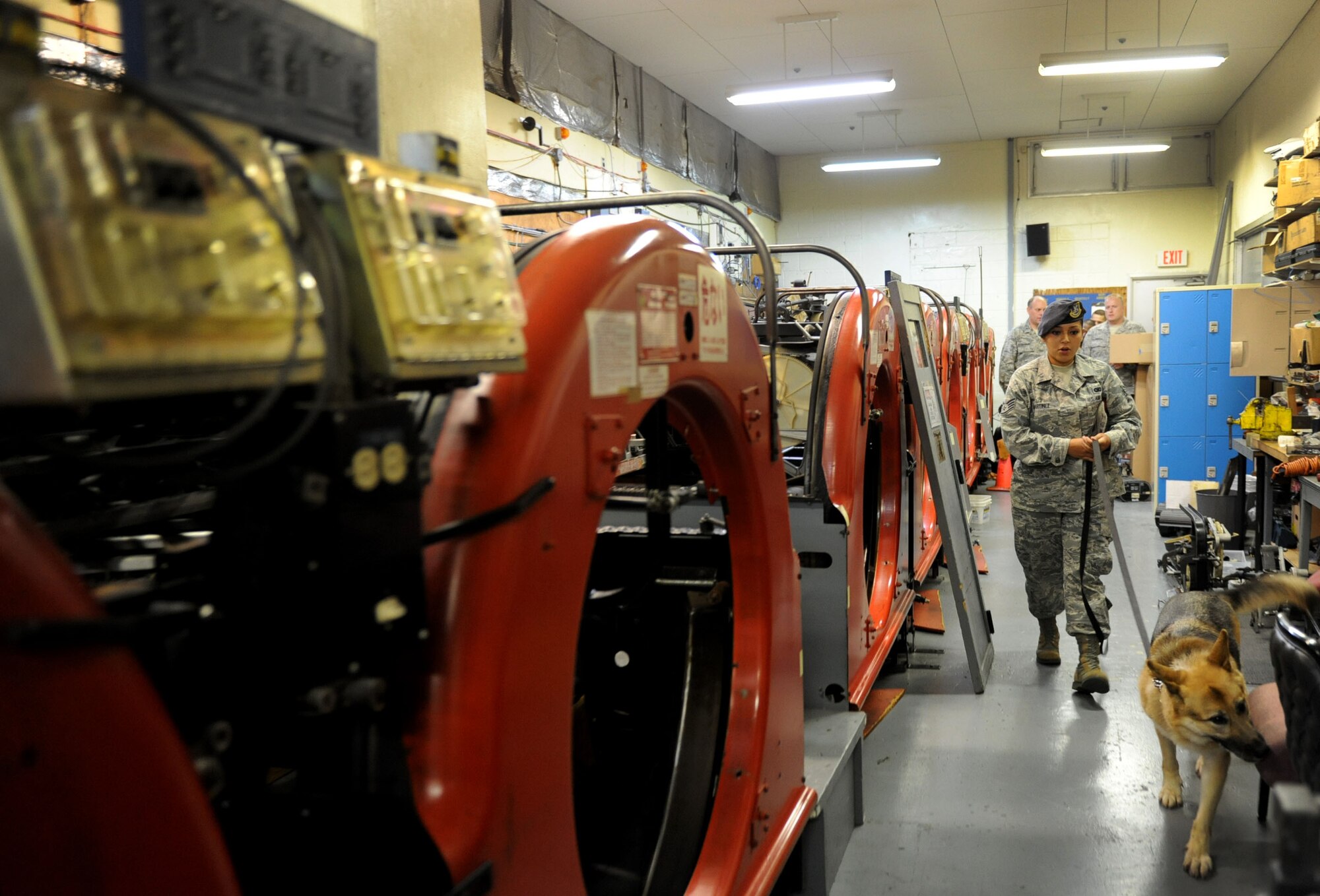 U.S. Air Force Staff Sgt. Natasha Martinez, 18th Security Forces Squadron military working dog handler, leads MWD Zina through the Skoshi Bowling Center in search of hidden narcotics in order to complete base certification on Kadena Air Base, Japan, Oct. 2, 2012. The trainers and MWDs had to find seven hidden narcotics throughout the building in order to pass. (U.S. Air Force photo/Airman 1st Class Brooke P. Beers)