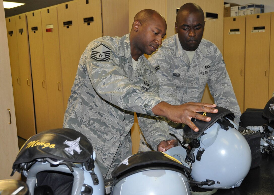 (Left) Master Sgt. Kevin Younger, 706th Fighter Squadron, explains to Airman 1st Class Keith Smith, 422nd Test and Evaluation Squadron Aircrew Flight Equipment Journeyman,  how to configure aircrew helmets with the Attenuation Custom Continuation Earpiece System. Younger is integrated into the 422nd TES as the Aircrew Flight Equipment flight chief. He was recently named the Air Force's Air Reserve Component Aircrew Flight Equipment Senior Noncommissioned Officer of 2011. (U.S. Air Force photo/Maj. Jessica Martin)