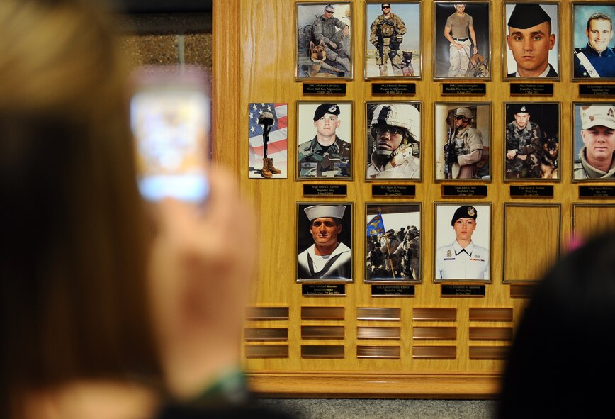 Kelly Nance takes a photo of the memorial in honor of the men and women who have fallen in combat while in the Security Forces career field at an annual Fallen Defenders and Master at Arms Dedication Ceremony held in the SFS guard mount room Offutt Air Force Base, Neb., Sept. 28.  Nance lost her brother, U.S. Navy Master at Arms 2nd class Sean Brazas, as he was serving in Panjaw’l, Afghanistan. (U.S. Air Force photo by Josh Plueger/Released)