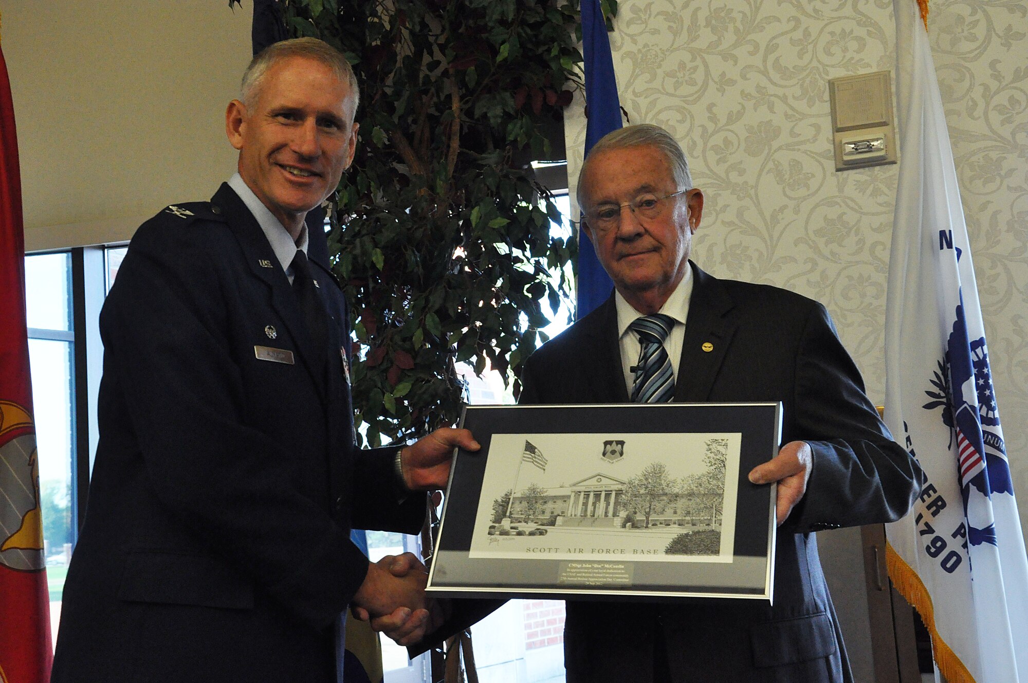 Col. David Almand, 375th Air Mobility Wing commander presents retired Chief Master Sgt. John “Doc” McCauslin, with an award for being the guest speaker at the 27th Annual Retiree Appreciation Day at the Scott Club at Scott Air Force Base, Ill. Sept. 28, 2012. McCauslin retired after 32 years of service to the Air Force. (U.S. Air Force photo/Airman 1st Class Jake Eckhardt)