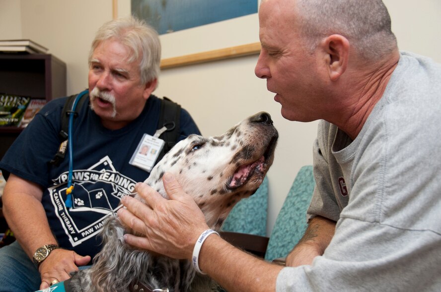 Crusader, the canine half of the pet therapy team offers Shawn Bonnington a
comforting doggie smooch while in the waiting room of the radiology clinic.
Charles Constantine and Crusader are one of three pet therapy teams that
visit David Grant Medical Center regularly. (Released - U.S. Air Force
Photograph/Heide Couch)